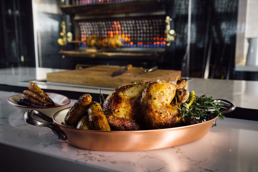 Pickett's Deli rotisserie cooked chicken with side dishes, sitting in front of the rotisserie